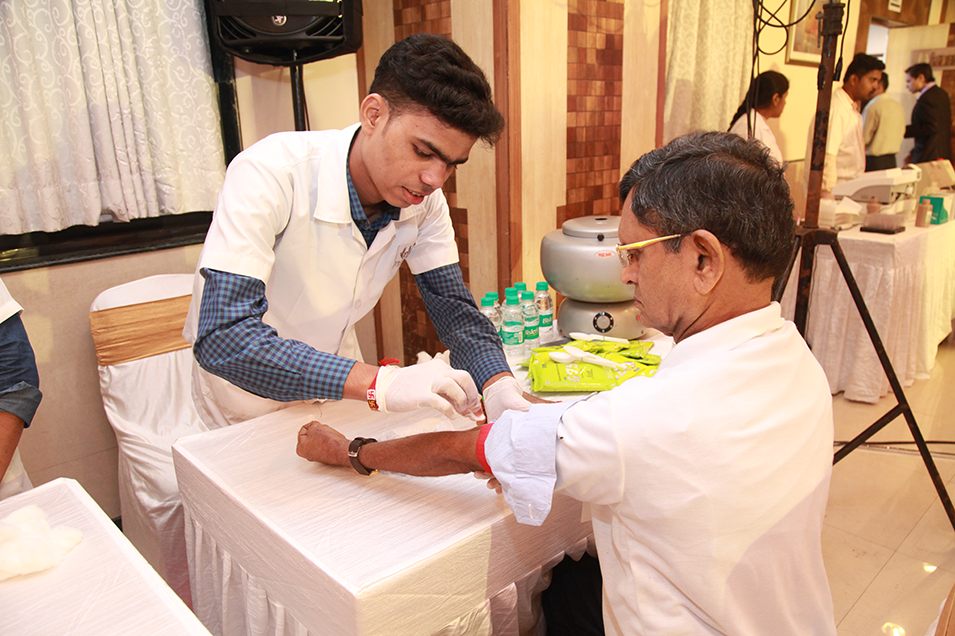 Madhavbaug medical staff collecting blood sample during Ayurvedic heart screening camp